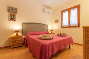 a bedroom with a bed with a red blanket at Oasi di Cala Pisana in Lampedusa