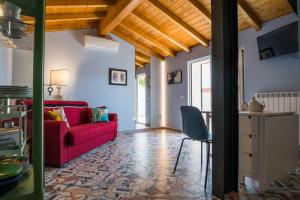 ein Wohnzimmer mit einem roten Sofa und einem Tisch in der Unterkunft Villa Silvana - Apt Giulia & Michela with terrace & parking in Perugia