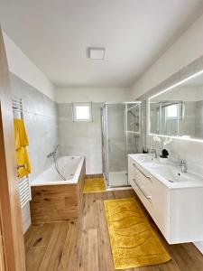 łazienka z 2 umywalkami, wanną i prysznicem w obiekcie Resort am Winklfeld 8a w mieście Schwanenstadt