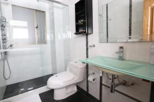 a bathroom with a white toilet and a sink at Hotel Suites 108 in Bogotá