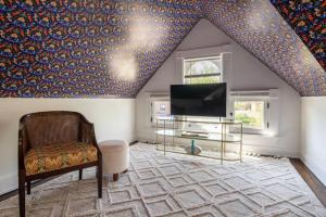 sala de estar con TV y silla en Spacious Studio Central Locale, en Cincinnati