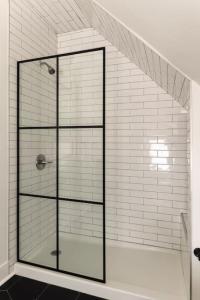 una ducha con puerta de cristal en un baño en Spacious Studio Central Locale, en Cincinnati 17 fotos más