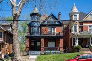 Una casa antigua con una torreta en una calle en Spacious Studio Central Locale, en Cincinnati