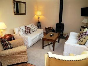 ein Wohnzimmer mit 2 Sofas und einem Holzofen in der Unterkunft Bogroy in Aberlour