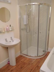ein Bad mit einer Dusche und einem Waschbecken in der Unterkunft Bogroy in Aberlour
