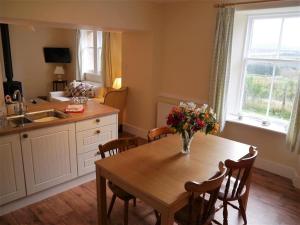 a kitchen with a table with a vase of flowers on it at Bogroy in Aberlour