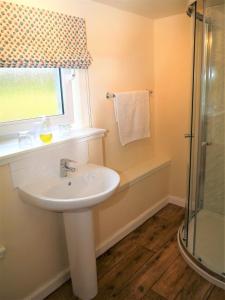 ein Bad mit einem Waschbecken und einer Dusche in der Unterkunft Bogroy in Aberlour