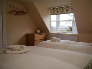 a bedroom with two white beds and a window at Bogroy in Aberlour