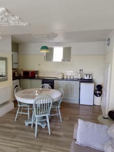 a kitchen with a table and chairs in a room at St Marys Apartment in Hastings