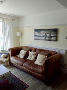 a brown leather couch sitting in a living room at St Marys Apartment in Hastings