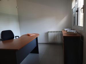 um escritório com uma secretária, uma cadeira e uma janela em Casa en Los Caminos del Vino - Chacras de Coria em Vistalba