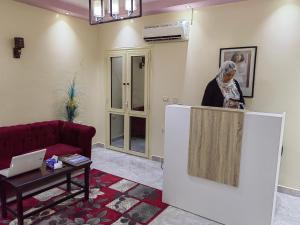 una mujer de pie detrás de un mostrador en una sala de estar en Adams Guest House, en El Cairo