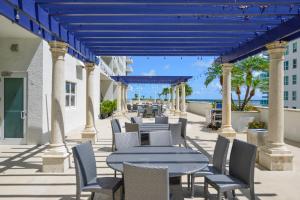 a patio with tables and chairs with the ocean in the background at Amazing Studio Apt @BRICKELL With pool & Parking in Miami