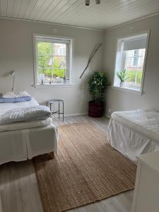- une chambre avec 2 lits et 2 fenêtres dans l'établissement Fjällbacka Villa, à Fjällbacka