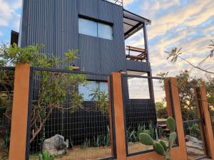 a house with a fence and a cactus at Casa Nuvem Lotf House + Suíte in Alto Paraíso de Goiás