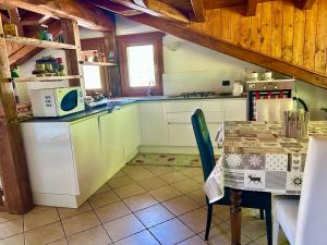 a kitchen with a table and a microwave in it at Mansarda luminosa in La Thuile
