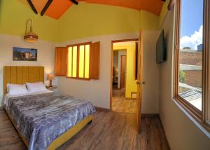 a bedroom with a bed and a large window at Hotel boutique casa Lily in Tunja