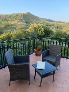 a patio with two chairs and a table on a balcony at Agriturismo Etna-Mare in Piedimonte Etneo