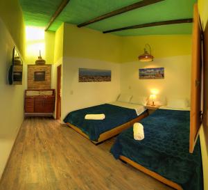 a bedroom with two beds and a wooden floor at Hotel boutique casa Lily in Tunja