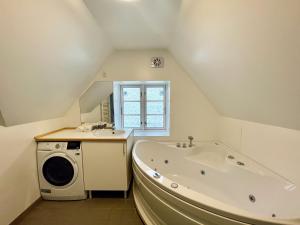 een badkamer met een bad en een wasmachine bij Large 5 Bedroom Flat in Lovely Urban Area in CPH Ø in Kopenhagen