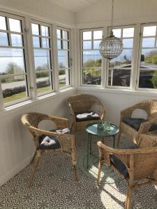 Vejbystrand的住宿－Underbar havsutsikt på bjärehalvön，配有椅子和桌子的房间,窗户