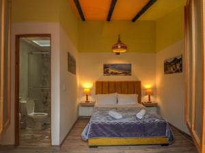 a bedroom with a bed and a shower and a toilet at Hotel boutique casa Lily in Tunja