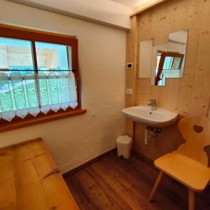 La salle de bains est pourvue d'un lavabo et d'une fenêtre. dans l'établissement Rifugio Stella Alpina Spiz Piaz per escursionisti, à Gardeccia - San Giovanni di Fassa