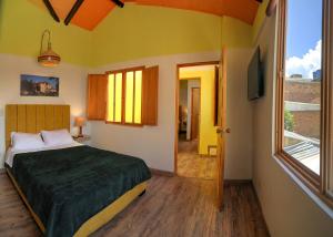 a bedroom with a bed and a large window at Hotel boutique casa Lily in Tunja