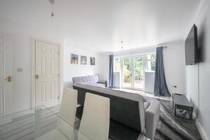 a white living room with a couch and a tv at Maidstone villa 3 bedroom free sports channels,parking in Kent