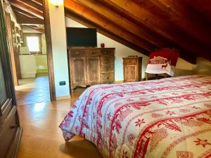 a bedroom with a bed and a tv in a room at Mansarda luminosa in La Thuile