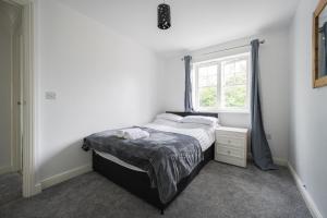 Habitación pequeña con cama y ventana en Maidstone villa 3 bedroom free sports channels,parking en Kent
