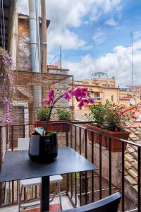una mesa y sillas en un balcón con flores en Accogliente intero appartamento, en Roma
