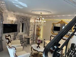 - un salon avec des chaises, un lustre et un escalier dans l'établissement Palace de Luxe, à Perast