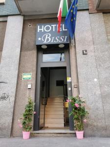 un hotel con due piante in vaso di fronte a un edificio di HOTEL BISSI a Milano