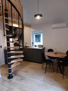 a kitchen and dining room with a spiral staircase and a table at Leśna Osada in Bystrzyca