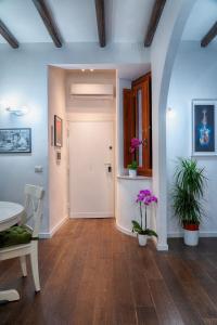 un pasillo con una puerta blanca, una mesa y flores en Accogliente intero appartamento, en Roma