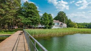 a house on a dock next to a lake at Wiartel Osrodek Wypoczynkowy in Pisz