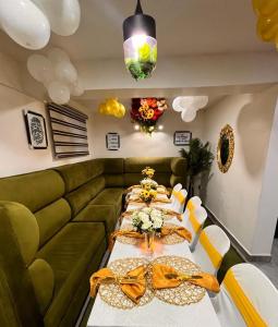 a dining room with a long table and a green couch at Ziroc Apartments Lekki Phase 1 in Lagos