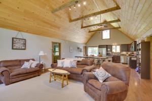 a living room with leather couches and a table at Spacious Cabin with Private Dock on Thompson Lake in Oxford