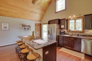 a kitchen with a large island with bar stools at Spacious Cabin with Private Dock on Thompson Lake in Oxford