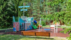 a playground in a park with a bench at Wiartel Osrodek Wypoczynkowy in Pisz