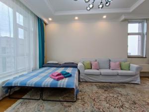 a living room with a couch and a bed at Tsengeldekh:Cozy 1 BR Apt•Queen bed•Naadam stadium in Ulaanbaatar
