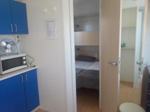 a small room with a bed and a microwave at Tiny house Chill escape para 7 - private Jacussy Brisa & Burbujas in Chiclana de la Frontera