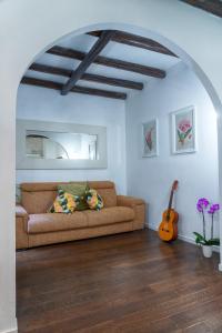 sala de estar con sofá y guitarra en Accogliente intero appartamento, en Roma