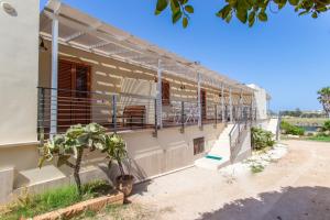 ein Gebäude mit einem Balkon auf der Seite in der Unterkunft Oasi di Cala Pisana in Lampedusa
