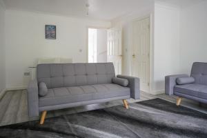 a living room with a couch and two chairs at Maidstone villa 3 bedroom free sports channels,parking in Kent