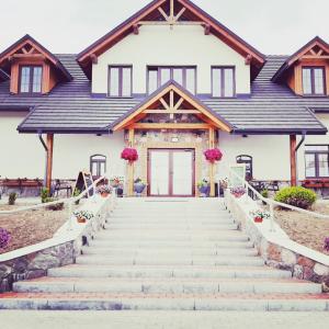 a house with stairs leading up to the front door at Makarewicz Dworek in Szypliszki