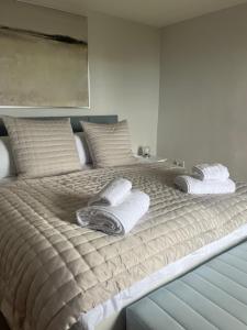 a large bed with towels and pillows on it at Seascape in Lynton