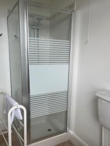 a shower with a glass door in a bathroom at Seascape in Lynton