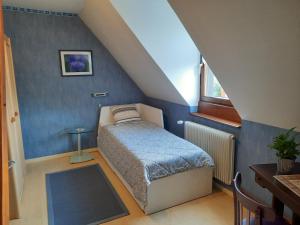 a small bedroom with a bed in a attic at Chambres d'hôtes "Au Val Séjour" in Saint-Martin